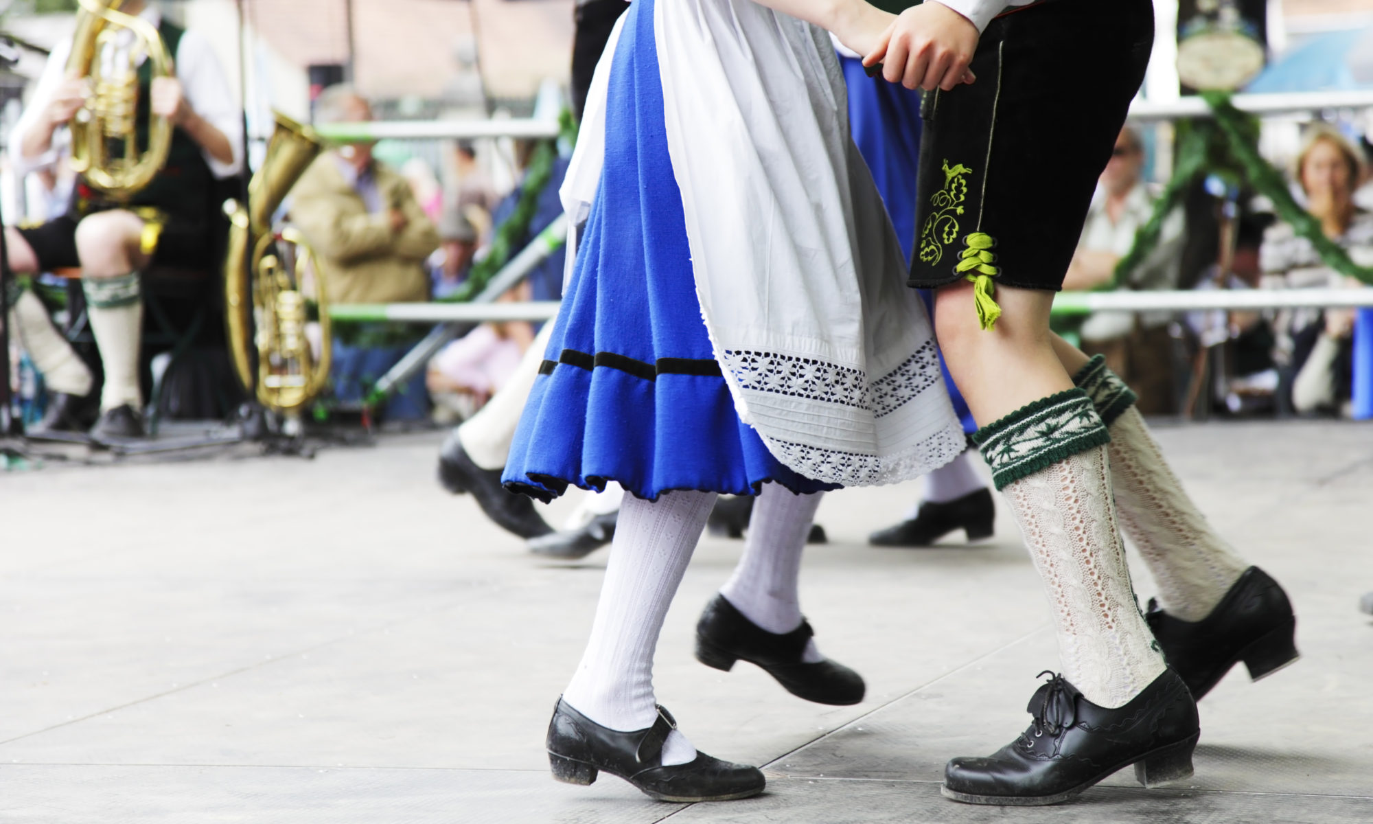 Couple in traditional Bavarian clothing dancing during Wurstfest