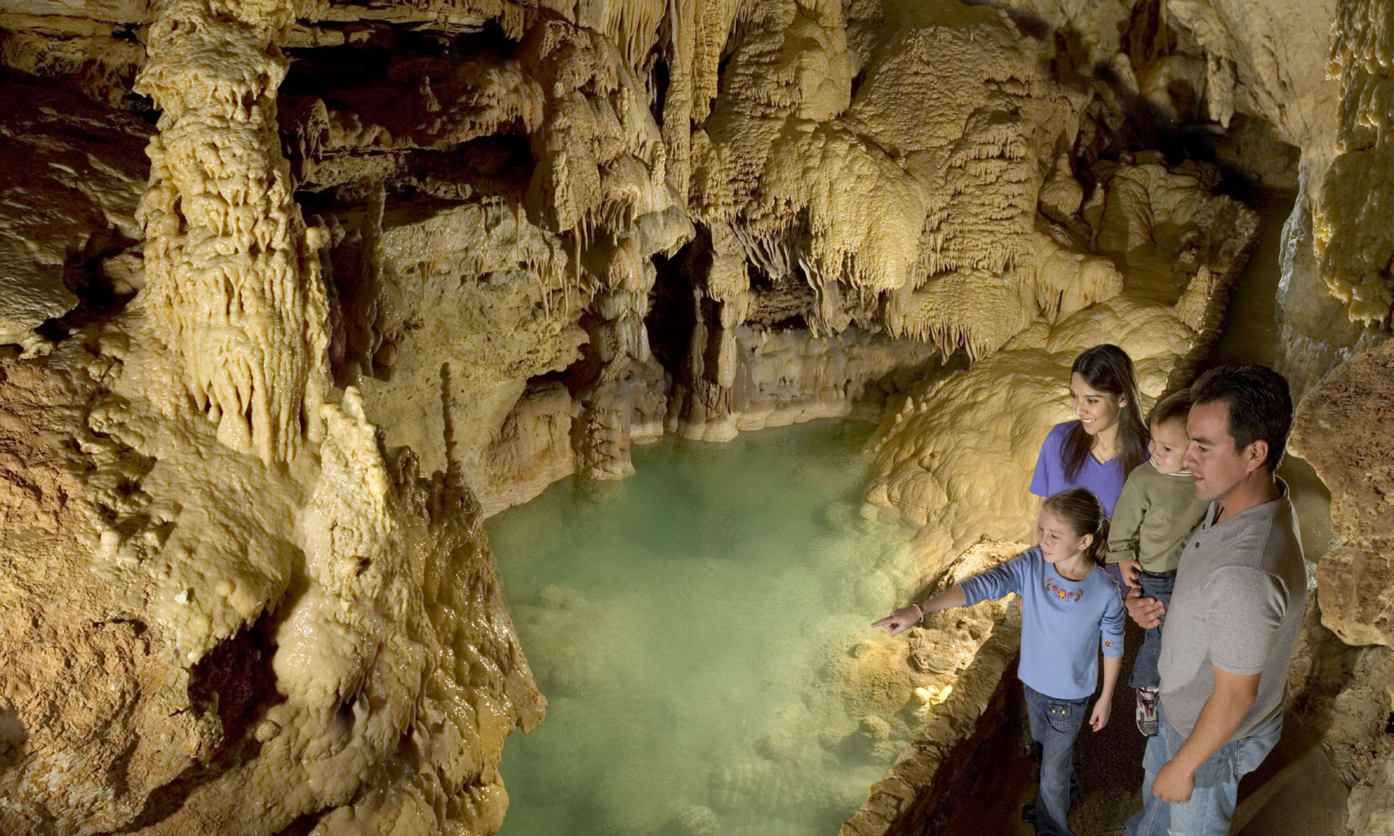 Visitors enjoying the Emerald Lake formation in Natural Bridge Caves