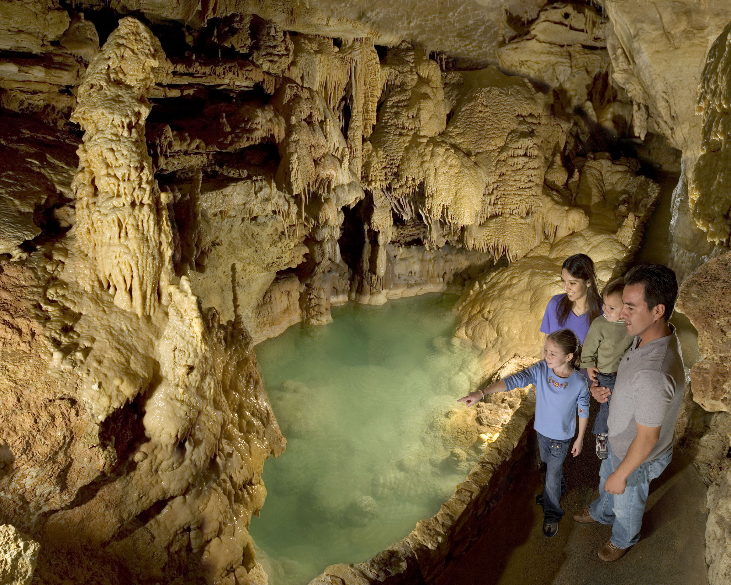 Visitors enjoying the Emerald Lake formation in Natural Bridge Caves