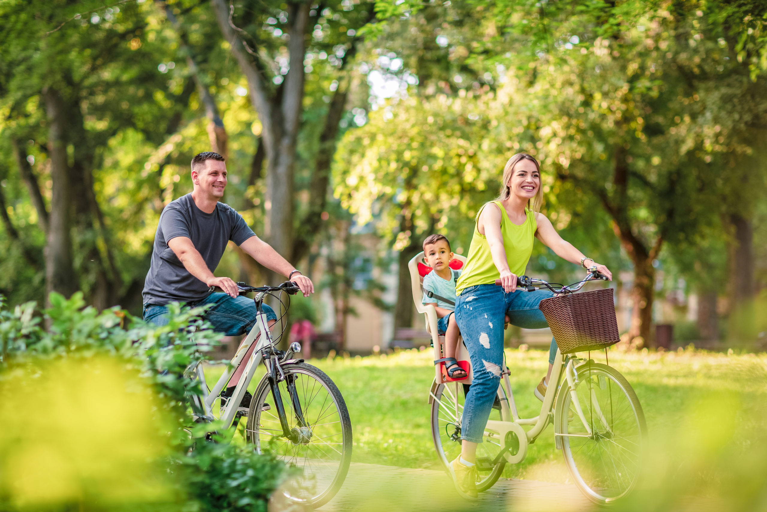 Happy family. Happy active father and mother with kid on bicycles having fun in park Happy active father and mother with kid on bicycles having fun in park.