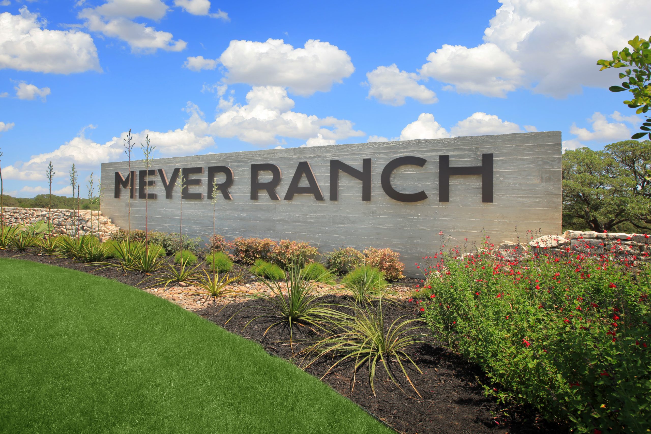 Meyer Ranch community entrance sign against blue sky filled with clouds