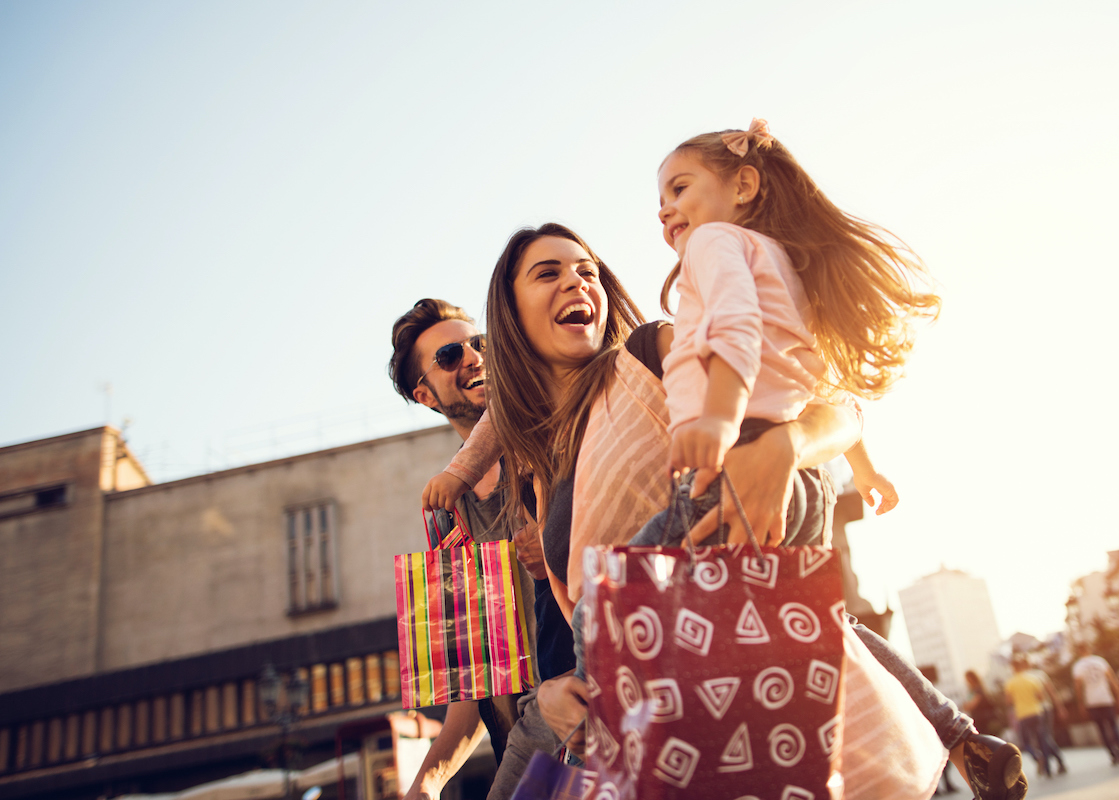 Low angle view of cheerful family having fun during a shopping day in the city.
